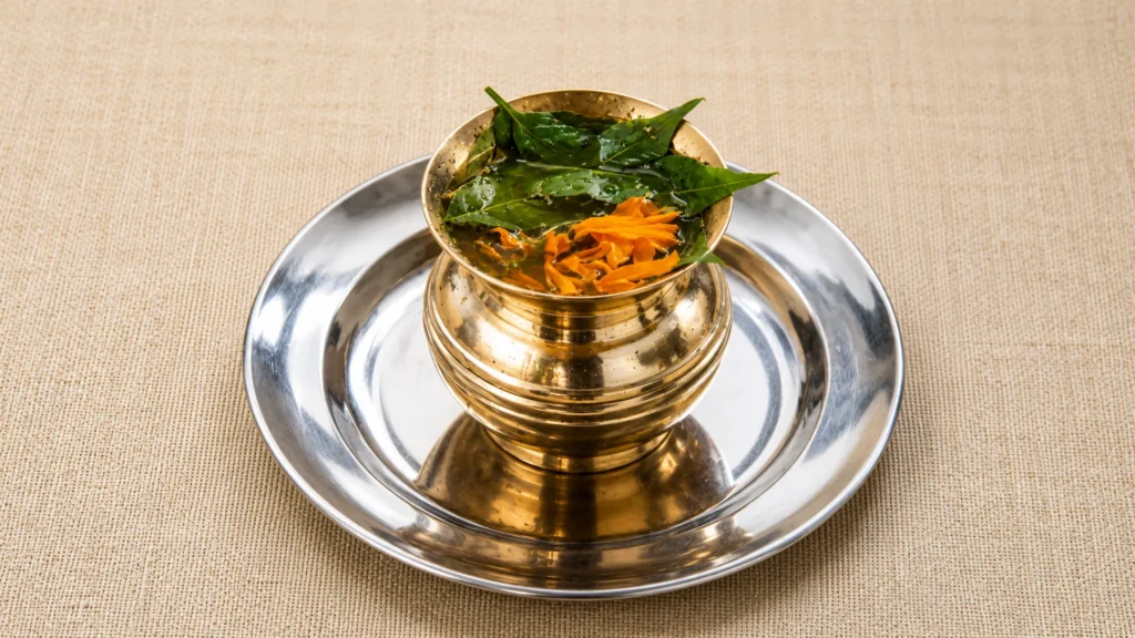 neem leaf and marigold water in brass kalash